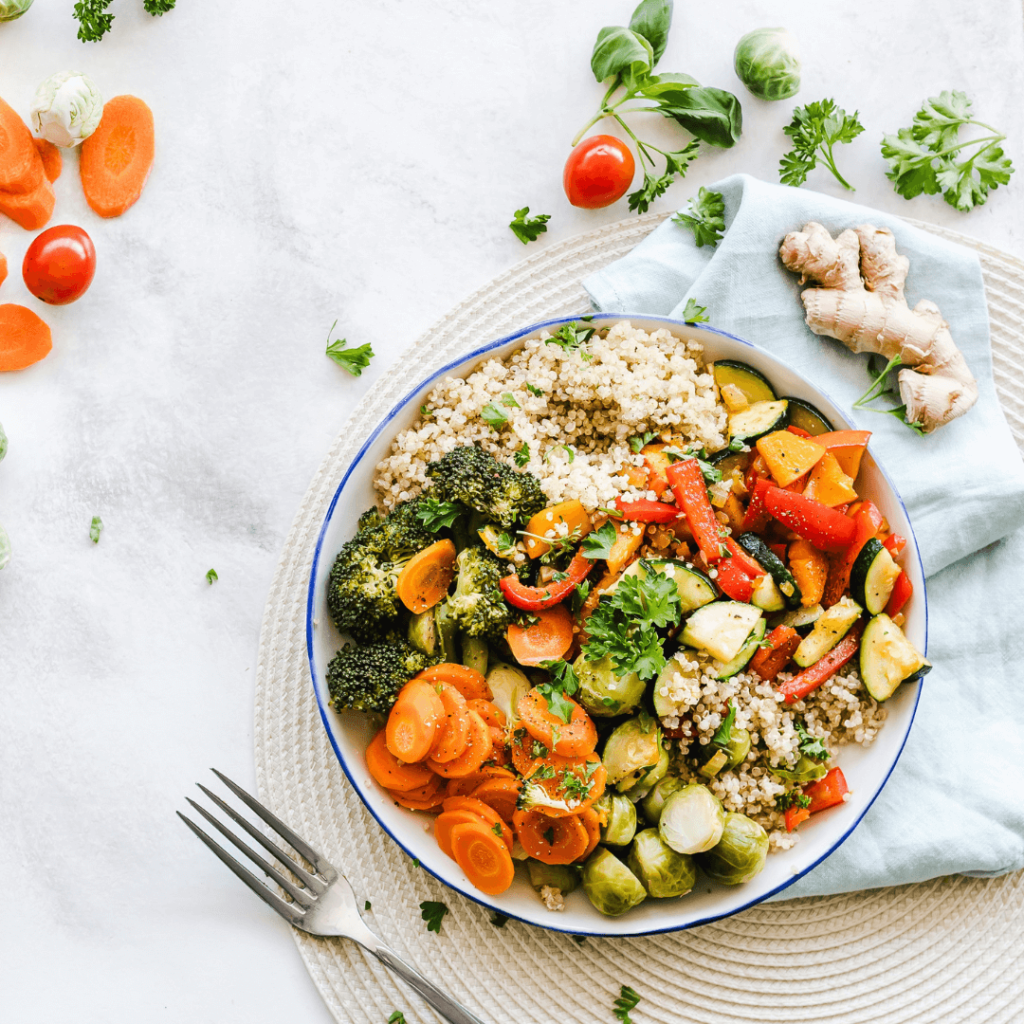 Bowl mit vielen gesunden Lebensmitteln wie Brokkoli, Möhren, Paprika, Zucchini, Ingwer und Couscous