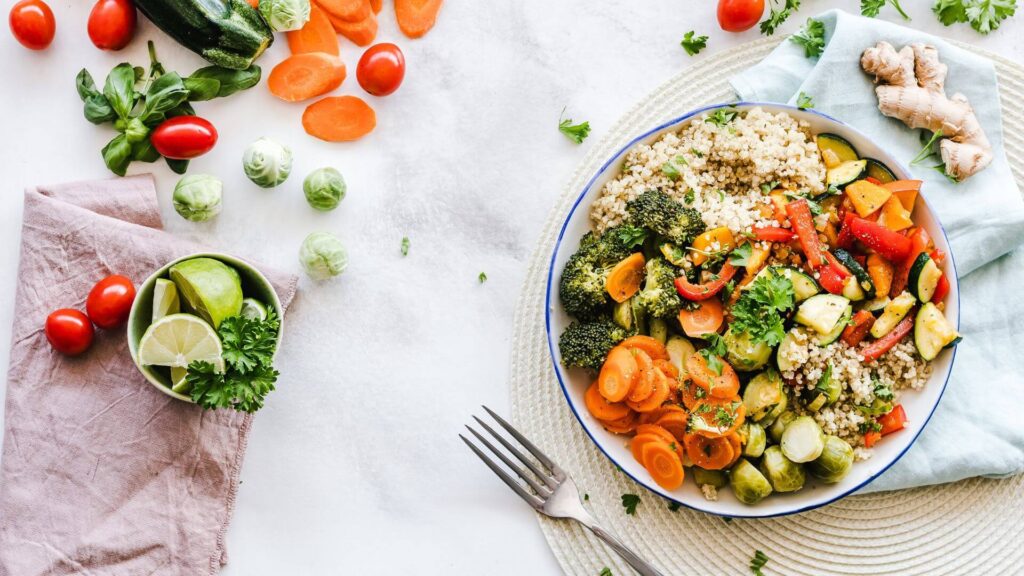 Bowl mit vielen gesunden Lebensmitteln wie Brokkoli, Möhren, Paprika, Zucchini, Ingwer und Couscous